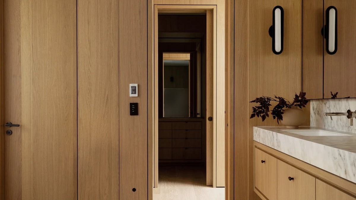Oak-paneled bathroom with a floating oak vanity and marble countertop